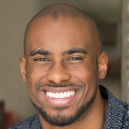 A photograph of elementary tutor Aaron looking at the camera and smiling. Aaron tutors grades K-8 including special ed and language arts.